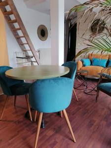 a table and chairs in a room with a staircase at Appart Terrasse in Strasbourg