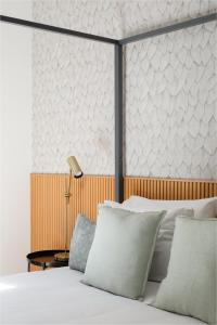 ein Schlafzimmer mit einem Bett mit weißen Kissen in der Unterkunft Aeterna Suites Roma in Rom