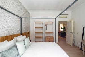 ein Schlafzimmer mit einem großen weißen Bett mit weißen Kissen in der Unterkunft Aeterna Suites Roma in Rom