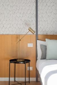 ein Schlafzimmer mit einem Bett und einem Tisch mit einer Lampe in der Unterkunft Aeterna Suites Roma in Rom