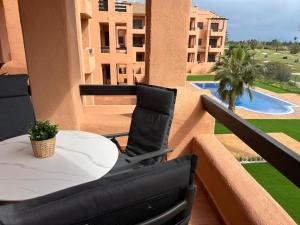 a table and chairs on a balcony with a pool at Casa Matthis in Los Alcázares