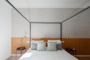 ein Schlafzimmer mit einem großen Bett und weißen Kissen in der Unterkunft Aeterna Suites Roma in Rom + 43 Fotos