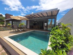 a swimming pool in front of a house at Bahia Soul - Casa Bambu - Barra Grande - Península de Maraú in Barra Grande