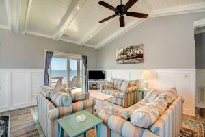 een woonkamer met banken en een plafondventilator bij Going Coastal in Surf City