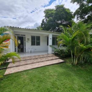 a small white house with a pathway leading to it at VILLETA, CASA CAMPESTRE CERCA DE PAYANDE in Villeta