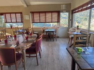a restaurant with tables and chairs and windows at Logis Hotel Restaurant Le Grand Puech in Mimet +53 photos