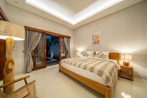 a bedroom with a bed and a window at Private Pool, Perfect Location -Your Exclusive 3-Bedroom Villa in Canggu -Book Now! in Kerobokan
