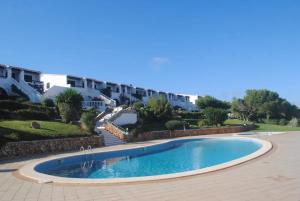 a swimming pool in a yard next to a building at Fee4Me Menorca Ideal Apartment 700m from the Sea in Arenal d'en Castell