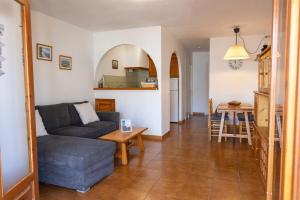a living room with a couch and a table at Fee4Me Menorca Ideal Apartment 700m from the Sea in Arenal d'en Castell