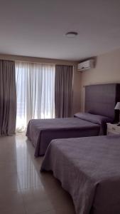 a hotel room with two beds and a window at Lofts & Suites in Rosario