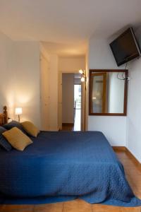 a bedroom with a blue bed and a mirror at Fee4Me Menorca Ideal Apartment 700m from the Sea in Arenal d'en Castell