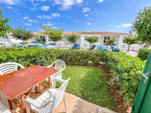a patio with a table and chairs in a yard at Fee4Me Menorca Ideal Apartment 700m from the Sea in Arenal d'en Castell