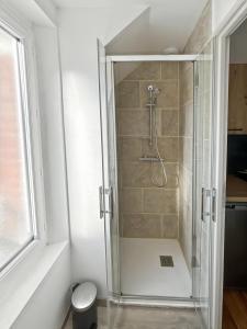 a shower with a glass shower stall in a bathroom at Studio Symphonie des Mers in Criel-sur-Mer