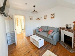 a living room with a couch and a fireplace at Studio Symphonie des Mers in Criel-sur-Mer
