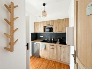 a kitchen with wooden cabinets and a refrigerator at Studio Symphonie des Mers in Criel-sur-Mer