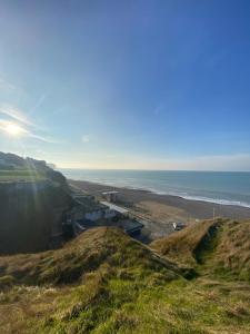 a view of the beach and the ocean from a hill at Studio Symphonie des Mers in Criel-sur-Mer
