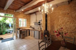 a kitchen with a table and a chandelier at le gîte de Claire maison avec terrasse, calme et confort, lit king size linge fourni in Couze-et-Saint-Front +14 photos