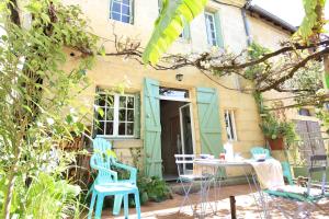 a patio with chairs and a table in front of a house at le gîte de Claire maison avec terrasse, calme et confort, lit king size linge fourni in Couze-et-Saint-Front