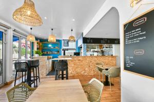 a restaurant with tables and chairs and a bar at Logis Hotel de France in Mimizan-Plage