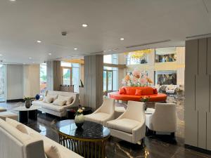 a living room with white furniture and a red table at Ao Tien Harbour Boutique Hotel in Hà Cái