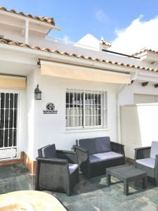 a patio with chairs and tables in front of a house at Gregorys Poolside Villa in Sucina +34 photos