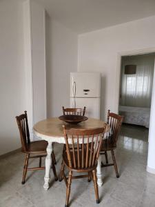 Savito Guest House mare في توري كان: طاولة طعام مع كراسي وثلاجة بيضاء