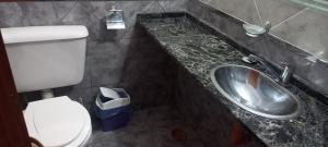 a bathroom with a toilet and a sink at Tres Lunas in La Falda