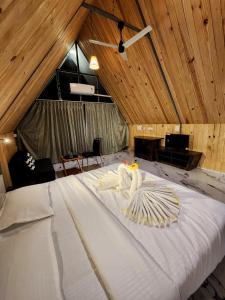 a large white bed in a room with wooden ceilings at Nirved Retreat Resort - A Backwater Forest Peaceful Stay in Bhor, Pune in Āpti