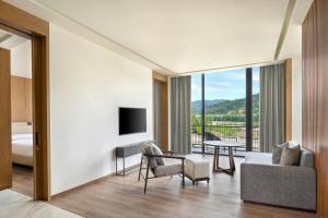a living room with a couch and a tv at Jim Corbett Marriott Resort & Spa in Rāmnagar