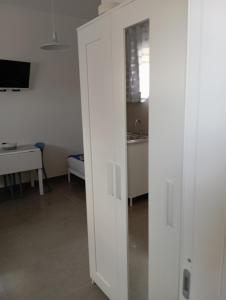 a sliding door in a room with a desk and a sink at La Piccola Gemma in Serramanna +4 photos