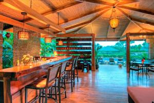 a restaurant with a bar with chairs and tables at Casa Chameleon Hotel Mal Pais - Adults Only in Santa Teresa Beach