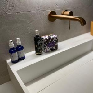 two bottles ofodorizers sitting on a bathroom sink at Nature loft, calme et confortable in La Murette