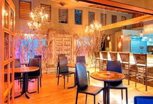 a restaurant with tables and chairs and a bar at Casa Chameleon Hotel Mal Pais - Adults Only in Santa Teresa Beach