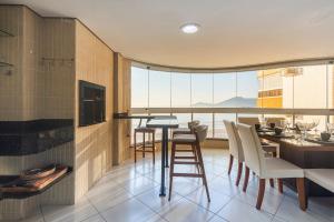 a kitchen with a table and chairs and a large window at ITNC091 - Incrível vista para o mar com 3Q+3WC in Balneário Camboriú