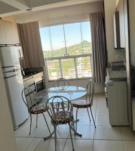 Una cocina con mesa y sillas y una ventana. en Refúgio Urbano - central c garagem, en Santa Maria