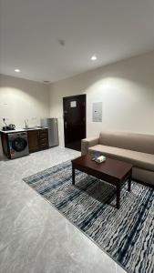 Una sala de estar con un sofá y una mesa de café. en White Beach Hotel Suites, en Rabigh
