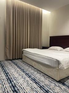 Un dormitorio con una cama grande y una ventana grande en White Beach Hotel Suites, en Rabigh