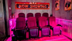 a group of red chairs in a room with pink lights at Lil Cabin in the Cove! MTN views, theater, hot tub, games, king beds, Prime Location! in Sevierville