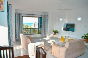 a living room with a couch and a large window at Kheyre Nyali Ocean View Two Bedrooms Apartments in Mombasa