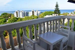 a white balcony with a table and a view of the ocean at Kheyre Nyali Ocean View Two Bedrooms Apartments in Mombasa