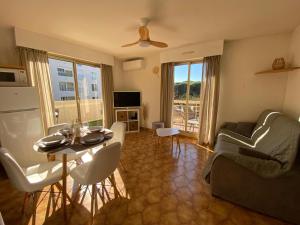 una sala de estar con una mesa y un sofá en Appartement Port Hyères 2 ch terrasses box, en Hyères