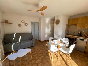 una sala de estar con un sofá, una mesa y sillas en Appartement Port Hyères 2 ch terrasses box, en Hyères