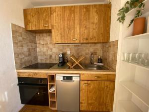 Una pequeña cocina con armarios de madera y lavavajillas. en Appartement Port Hyères 2 ch terrasses box, en Hyères 6 fotos más