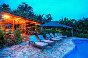 a group of chairs and umbrellas next to a pool at Casa Chameleon Hotel Mal Pais - Adults Only in Santa Teresa Beach