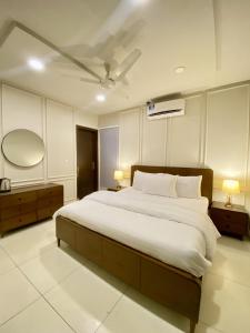 a bedroom with a large bed and a mirror at The Atrium Apartments Opposite GIGA Mall - SUPERHOST STAYS in Islamabad