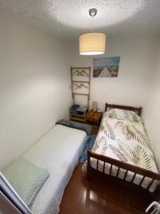 1 dormitorio con 2 camas y luz colgante en 2 bed room apartment , sea view, 10 minutes walk to the beach, en Ribeira Brava