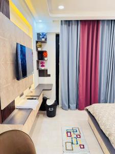 Un dormitorio con una cama y un escritorio con televisión. en Hotel Omaxe Hazratganj, en Nalmatha