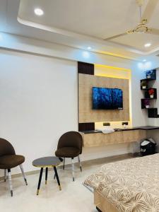 Una sala de estar con dos sillas y una mesa. en Hotel Omaxe Hazratganj, en Nalmatha 3 fotos más