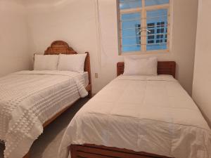 a bedroom with two beds and a window at Casa muy cerca de plaza central in San Cristóbal de Las Casas