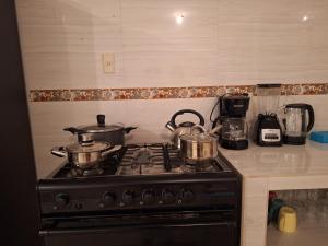 a stove with pots and pans on top of it at Casa muy cerca de plaza central in San Cristóbal de Las Casas